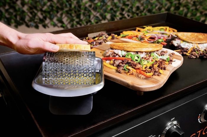 The steel butter roller is placed on the griddle, surrounded by bread and sandwich essentials.