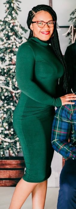 A customer showcasing the dress in a rich green hue.