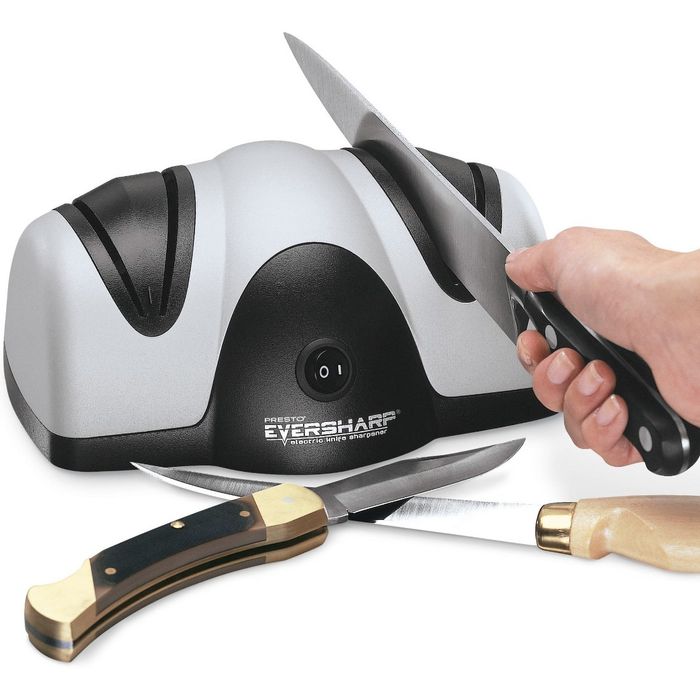 The black and silver device, labeled 'PRESTO EVERSHARP ELECTRIC KNIFE SHARPENER,' is surrounded by three knives.
