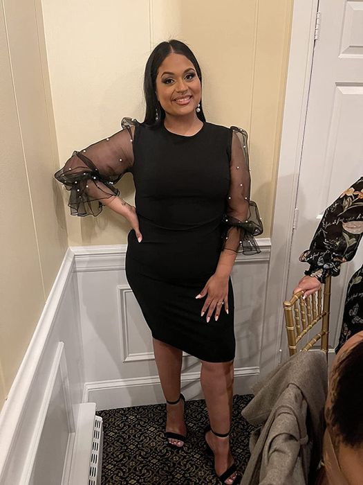 A reviewer wearing the dress in a classic black shade