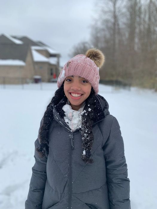 person wearing a pink beanie with a pom-pom on top