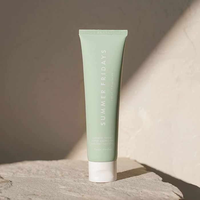 A standing tube of Summer Fridays Super Amino Gel Cleanser is showcased on a stone surface, with shadows cast in the background.
