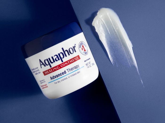 Jar of Aquaphor Healing Ointment next to a sample of the ointment