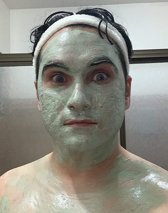 A person wearing a facial mask and headband gazes directly at the camera with an expression of surprise.