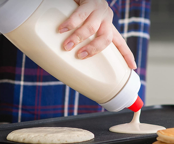 A model pouring pancakes from a convenient handheld, bottle-shaped dispenser for a perfect breakfast.