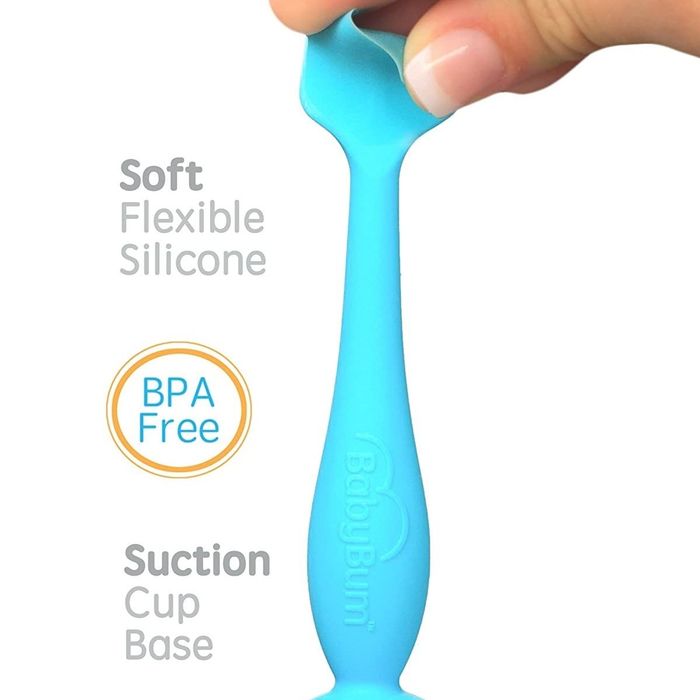 A blue silicone applicator, with a person's finger gently pressing on the tip to demonstrate its softness and flexibility.