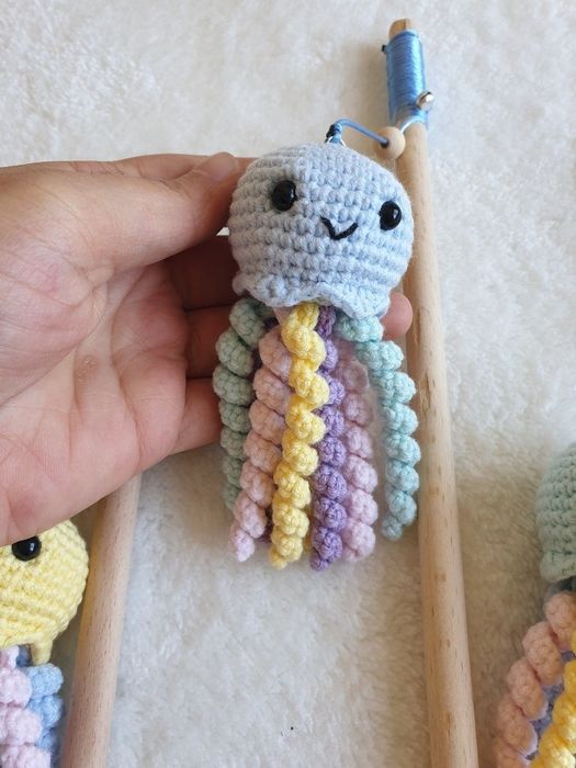a hand grasping one of the crocheted octopus toys