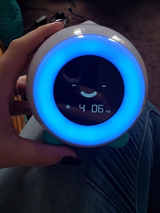 A review photo showing the clock with a digital face that has closed eyes, signaling 'bedtime.'