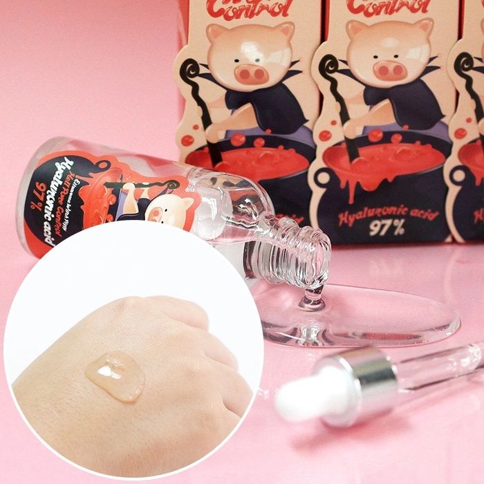 Serum spilling from a bottle, with a drop of it on a hand to showcase its texture