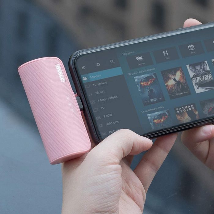 The pink iWalk portable charger plugged into an iPhone, ready to power up.