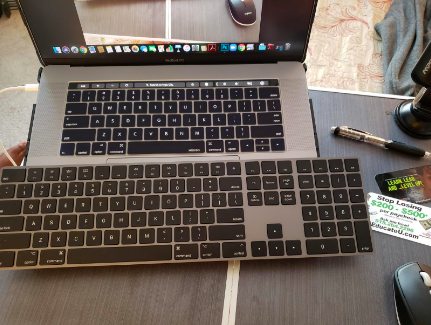The keyboard is placed next to the reviewer's laptop.