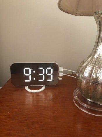 The alarm clock placed on a reviewer's nightstand, adding a sleek touch to their space.