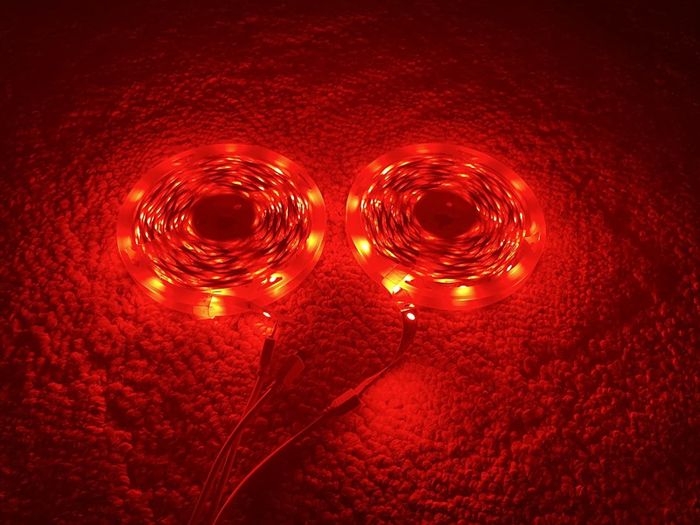 The light strips coiled in their roll, glowing in a rich red hue.