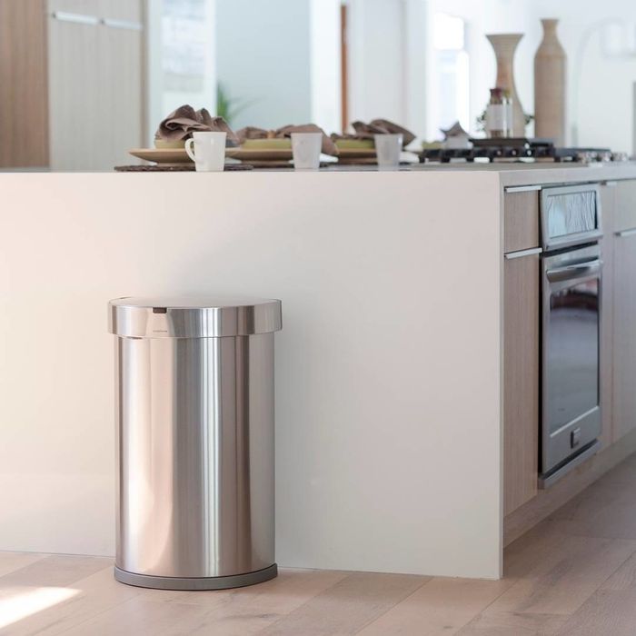 The stainless steel trash can placed next to a kitchen counter for easy access.