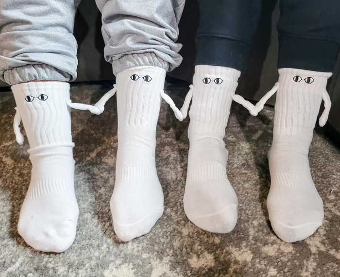 Two pairs of socks worn by reviewers holding hands