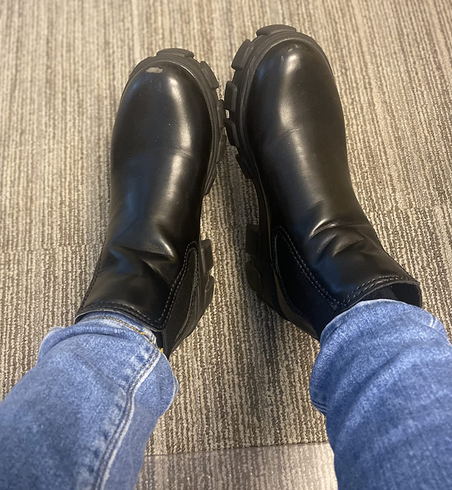 A reviewer displaying the black boots.