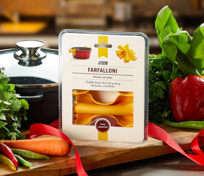 Packaging for Farfalloni silicone pot grips, placed next to fresh vegetables and a cooking pot, highlighting essential kitchen tools.