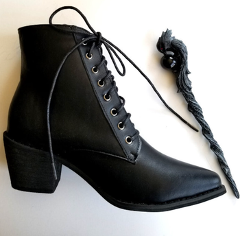 One boot positioned beside a wand.