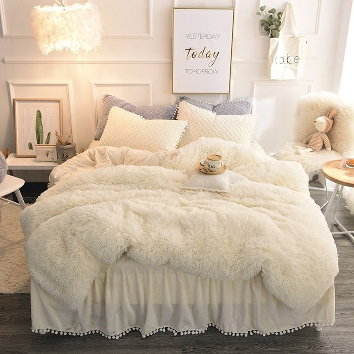 The off-white faux fur duvet set adorning a bed, adding a soft, cozy touch to any room.