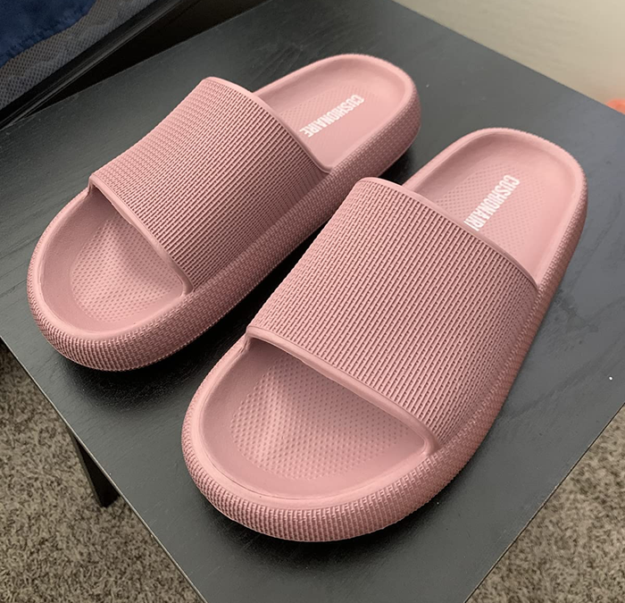 A photo of a reviewer showing off the pink rubber soles.