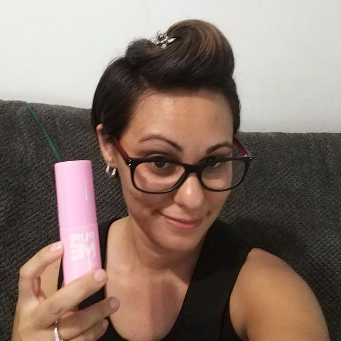 A reviewer modeling the dark hair powder while holding it in her hand.