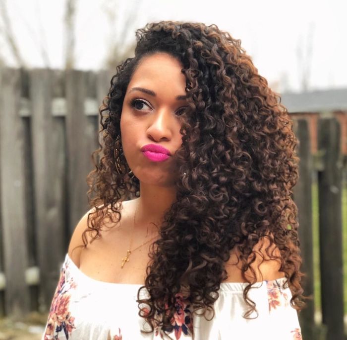 A reviewer with long, defined curls that shine.
