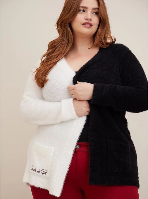 A model wearing a black-and-white cardigan with a black shirt and red pants