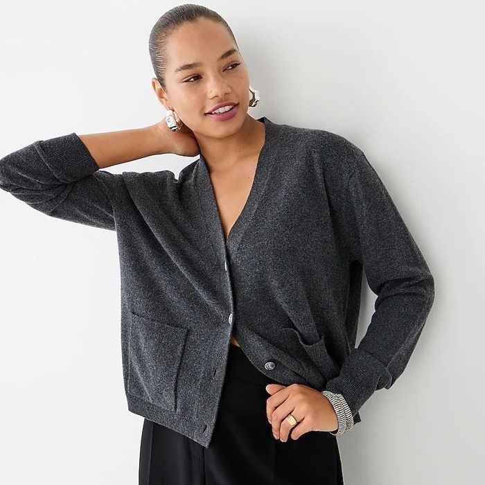 A model dressed in a grey cardigan and black pants.