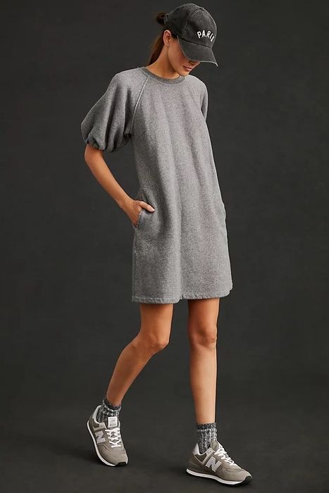A model showcasing a grey dress paired with coordinated socks, shoes, and a stylish black hat.