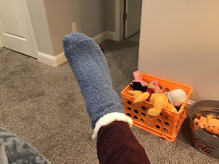 A reviewer showcasing grey-and-white socks paired with brown pants