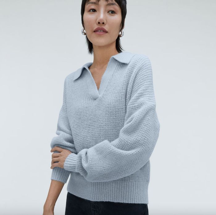 A model dressed in a blue sweater and black pants
