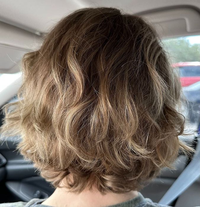A reviewer with soft, wavy hair that looks smooth and short.