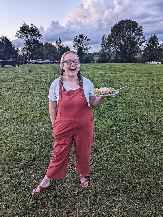 A reviewer showcasing red overalls
