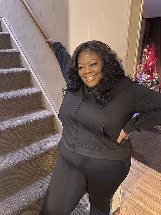 A reviewer showcasing a matching black sweatsuit.