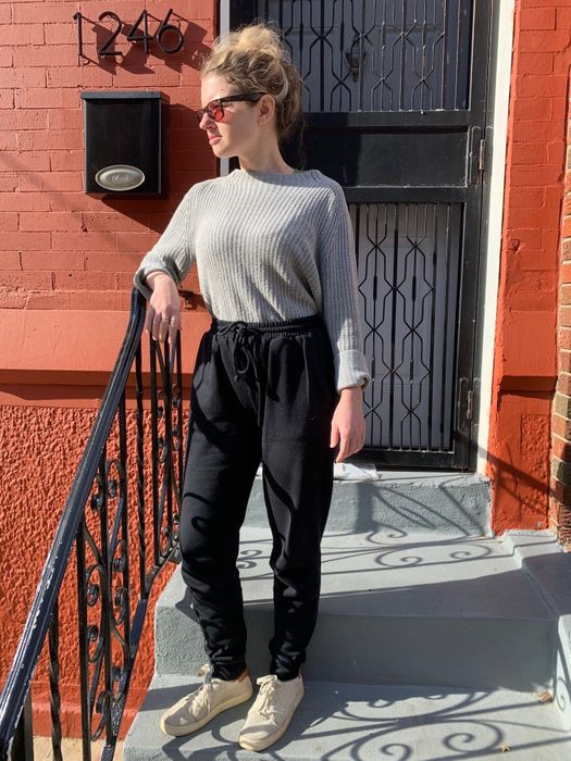 The writer is wearing black joggers.