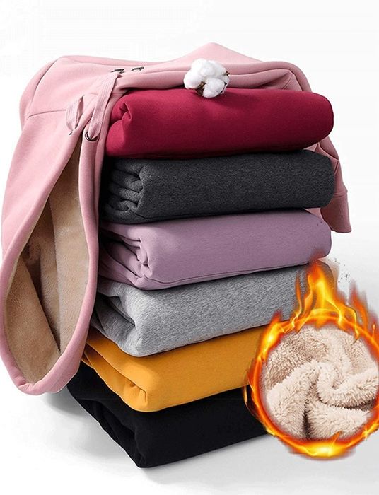 Seven hoodie colors folded and stacked, with an inset showing the soft sherpa lining inside.