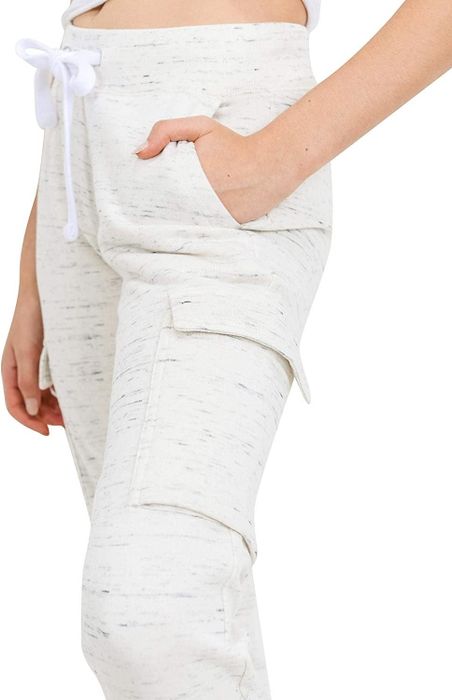 A close-up of beige joggers featuring the cargo pocket and a drawstring waist.