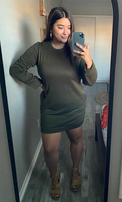 Reviewer wearing the dark green sweatshirt dress.