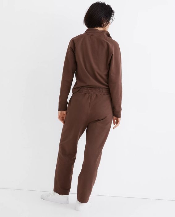 The back view of the model wearing brown sweatpants.