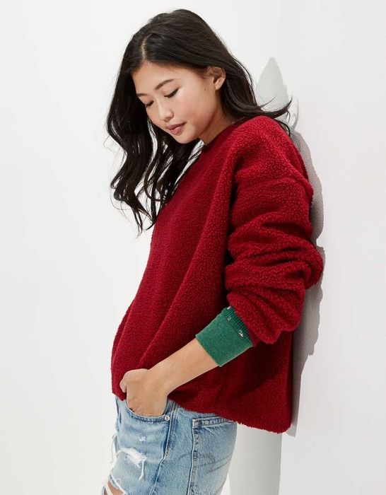 The model is sporting a vibrant red sweatshirt.