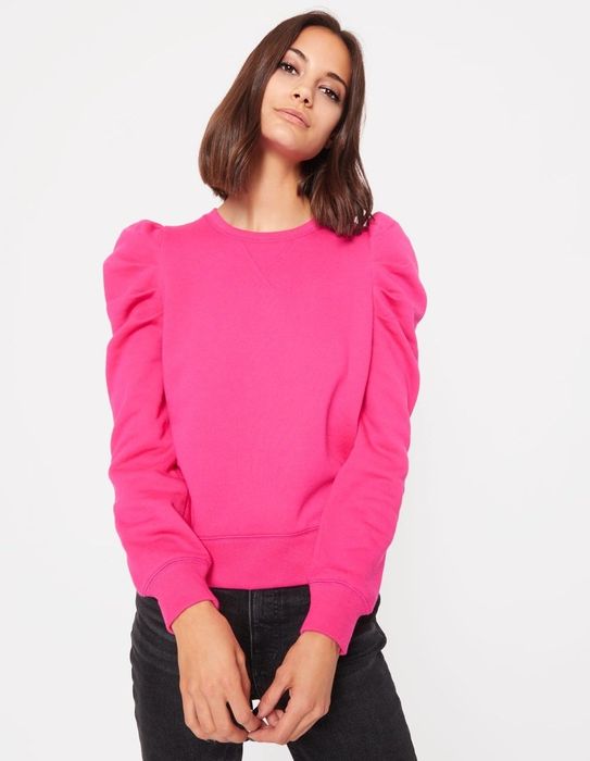 The model is wearing a vibrant hot pink sweatshirt.