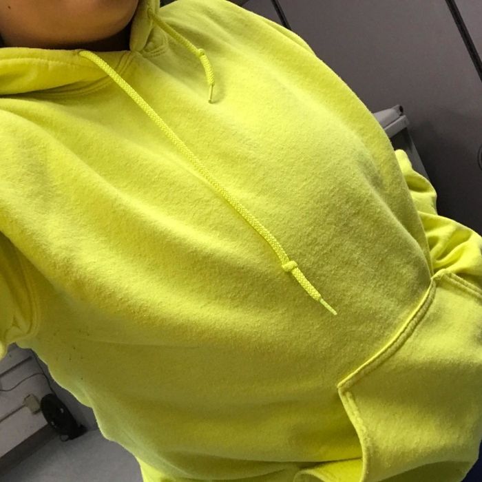 A close-up shot of a reviewer wearing a vibrant yellow hoodie.