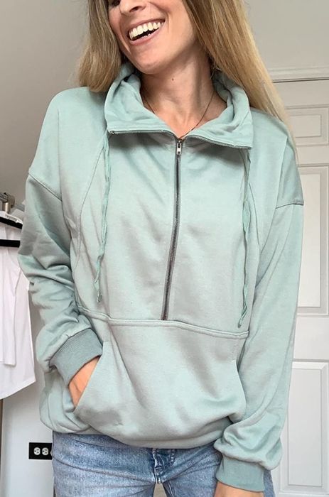 Reviewer wearing the light green sweatshirt with the zipper fully closed.