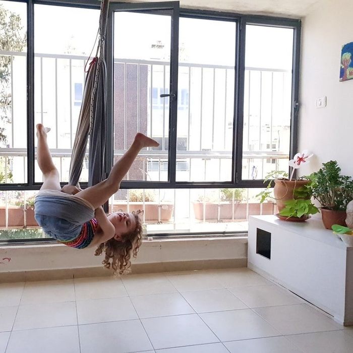 Another child using the chair as a swing, turning it into a jungle gym adventure