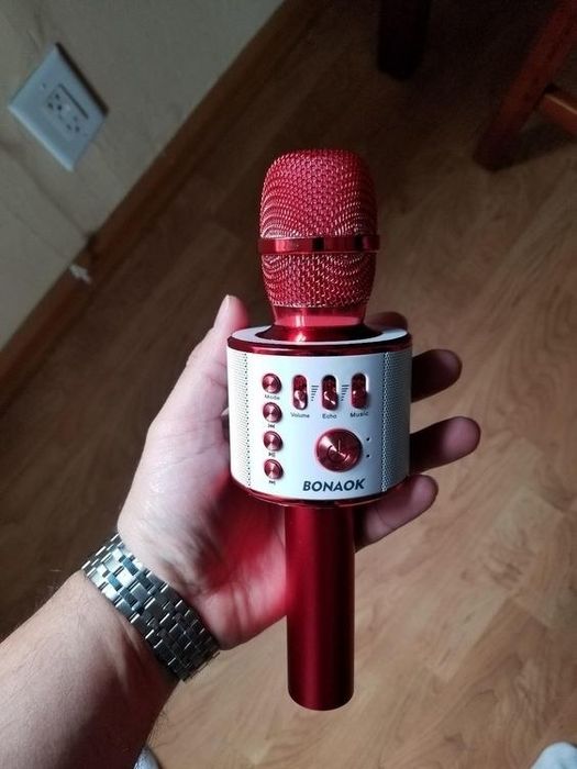 A reviewer holding the red karaoke microphone, ready to turn any moment into a karaoke session.
