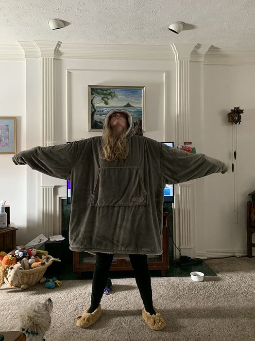 A reviewer is seen wearing a grey sweatshirt that extends all the way down to their knees.
