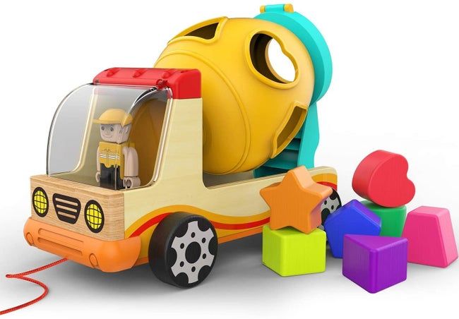The wooden truck, complete with a toy figure, a plastic cement mixture, and six vibrant wooden shapes, ready for play.