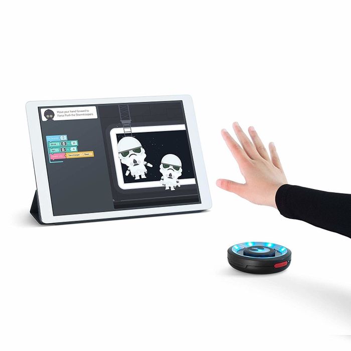 A hand manipulating images on a screen using the sensor.