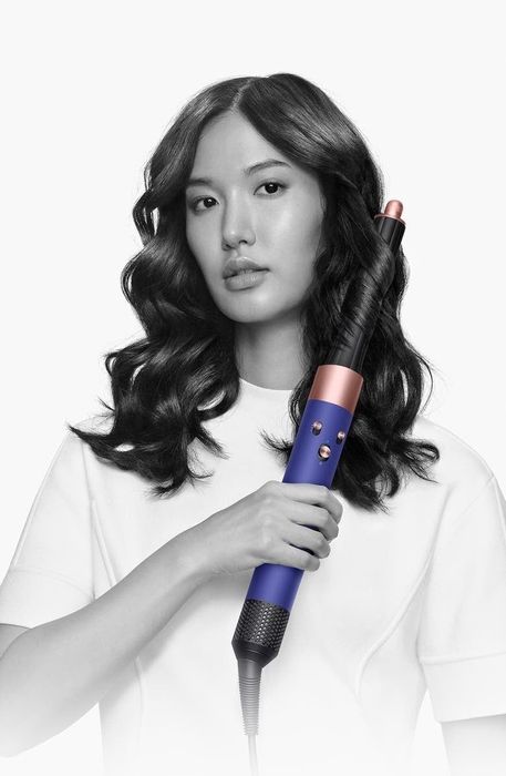A model showcasing the curling attachment, effortlessly creating defined curls.