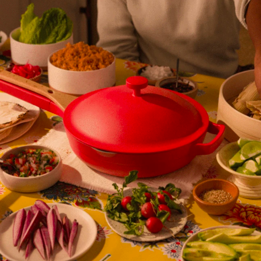 The Always Pan with a lid, presented in a vibrant red color, combining style and function.
